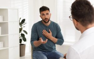 A doctor offering personalized rehabilitation and education about safe pain management to a man.