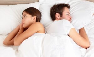 A couple in bed facing sexual problems due to alcohol